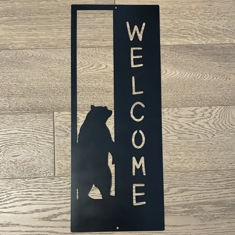 Black steel vertical WELCOME sign with a standing bear.
