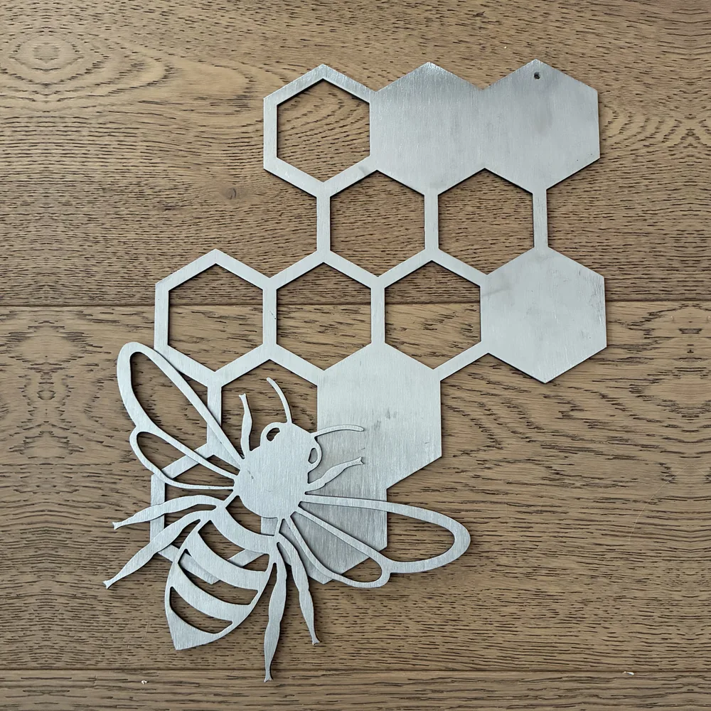 Plain metal bee beside a cluster of honeycomb hexagons.