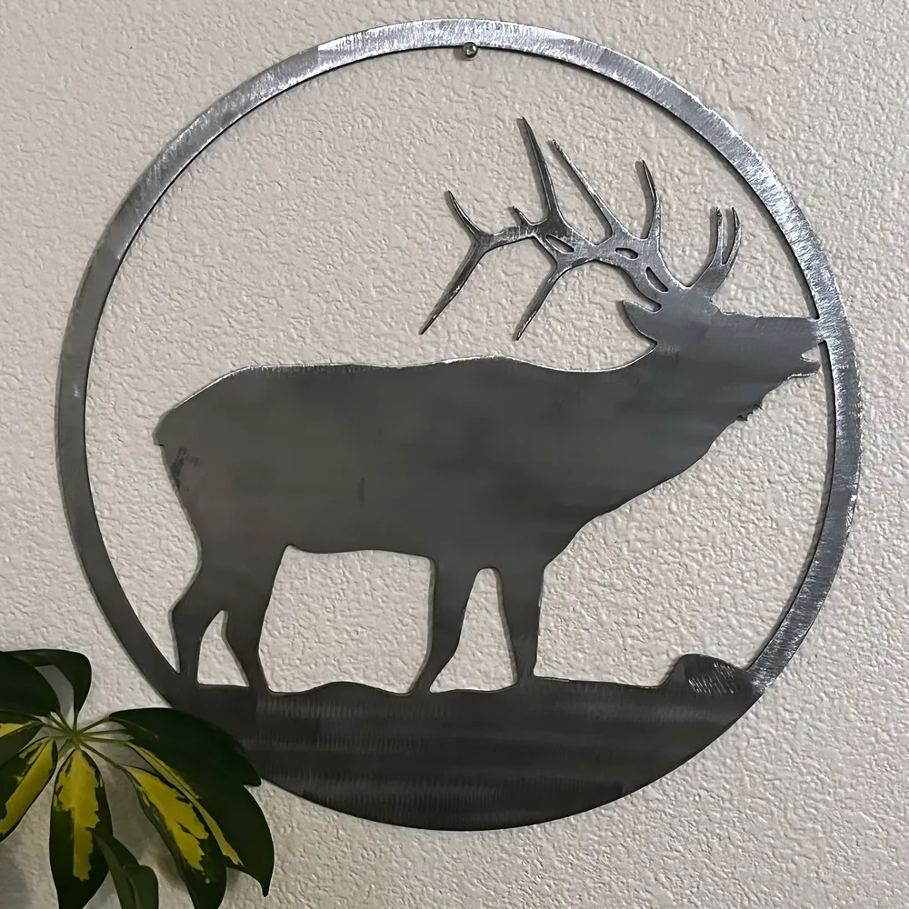 Raw steel round with a bugling elk cut out.