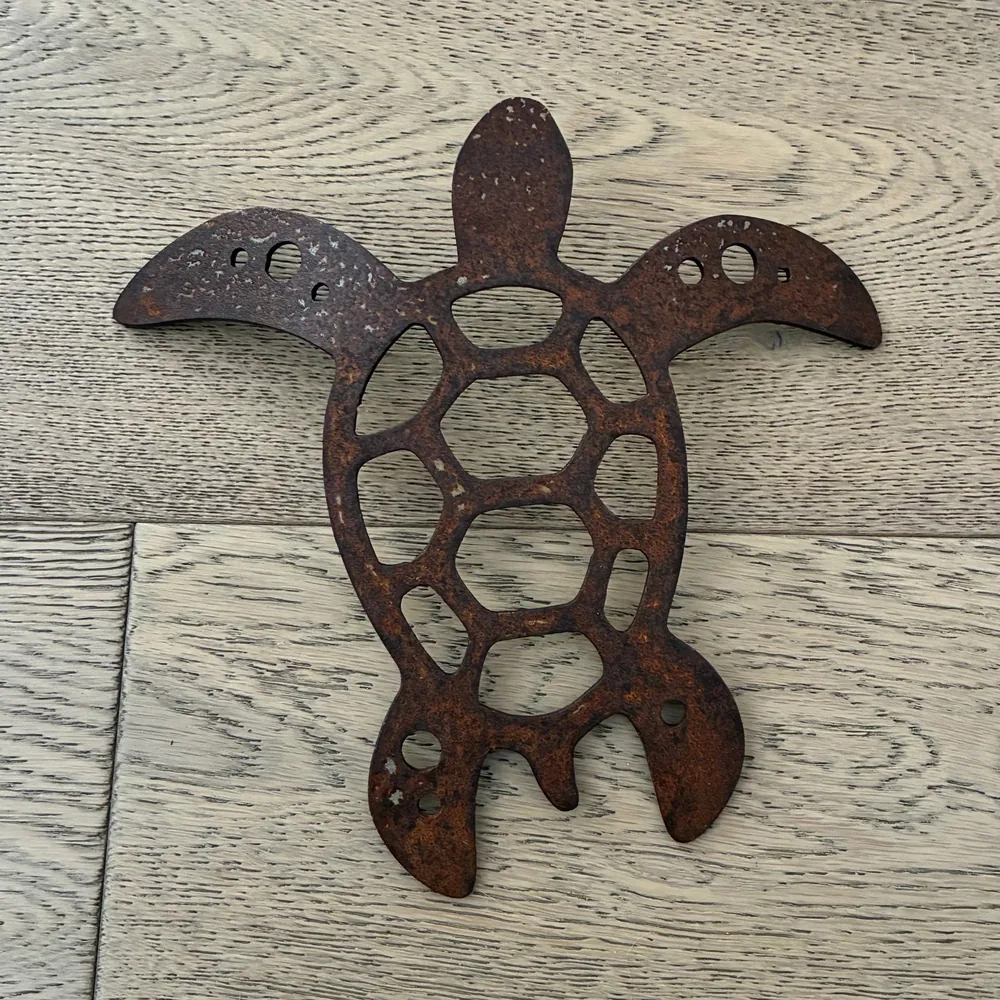 Rusted metal sea turtle with a cut-out shell pattern.